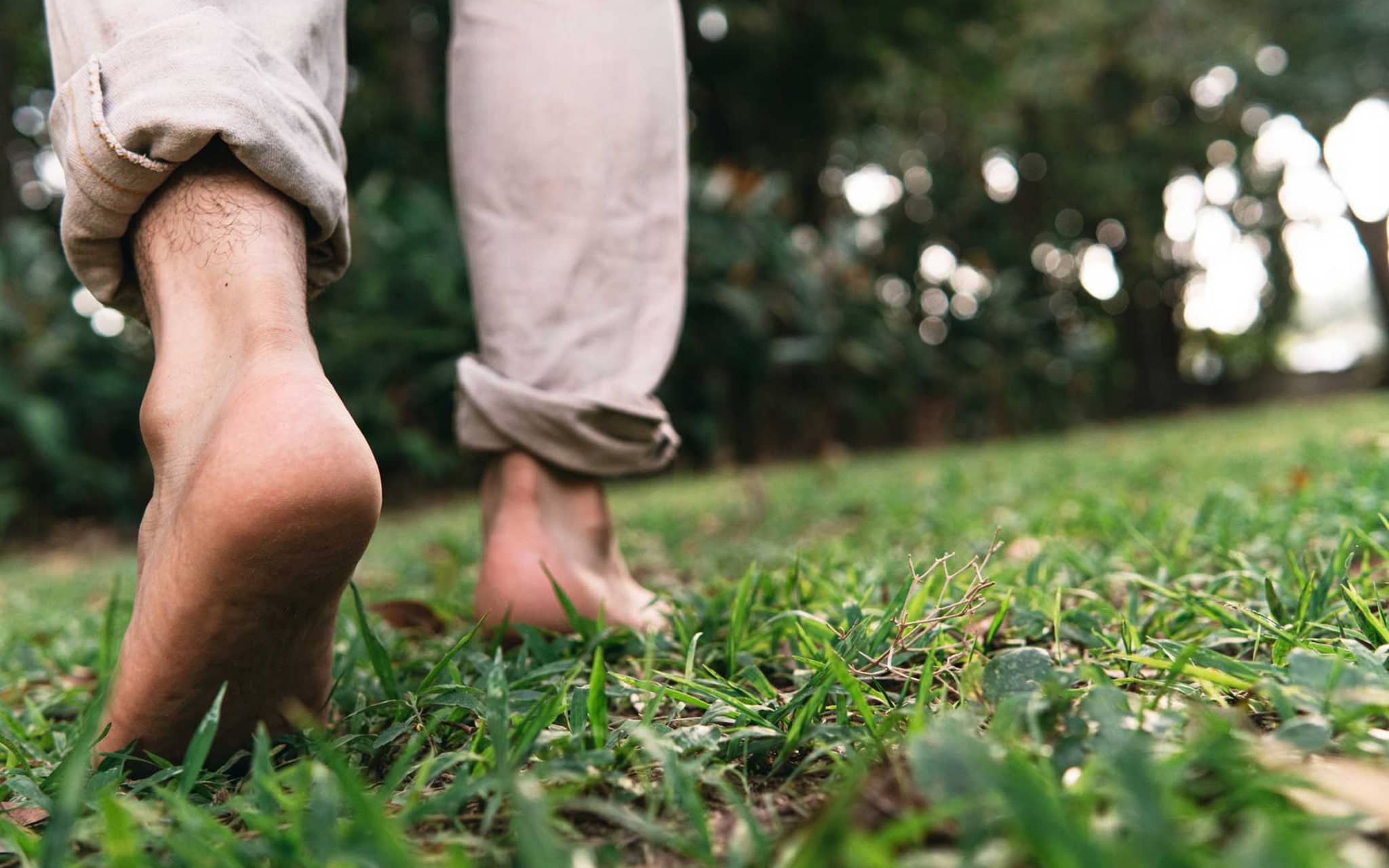 Symbolbild Diabetischer Fuß: Mann läuft barfuß im Gras