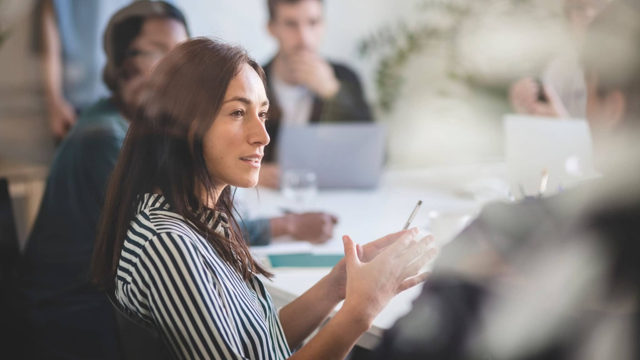 Image: Woman talking to colleagues.