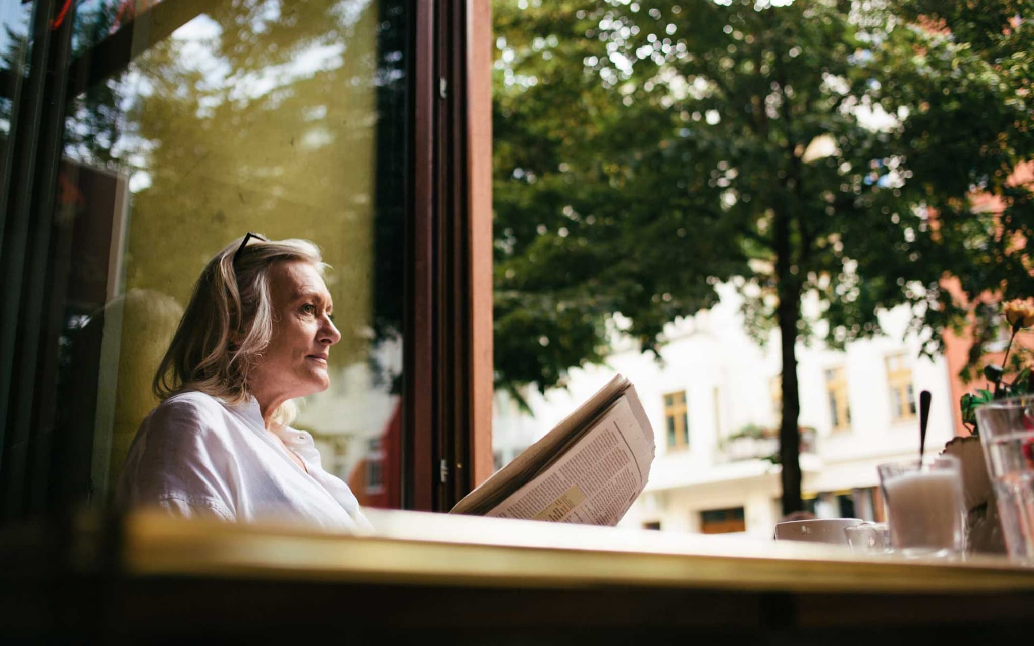 Symbolbild Exazerbation bei COPD: Frau sitzt allein in einem Café