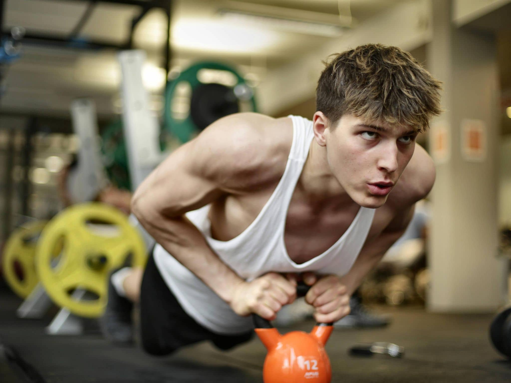 Penis-Unfälle: Junger Mann im Fitnessstudio beim Sport.
