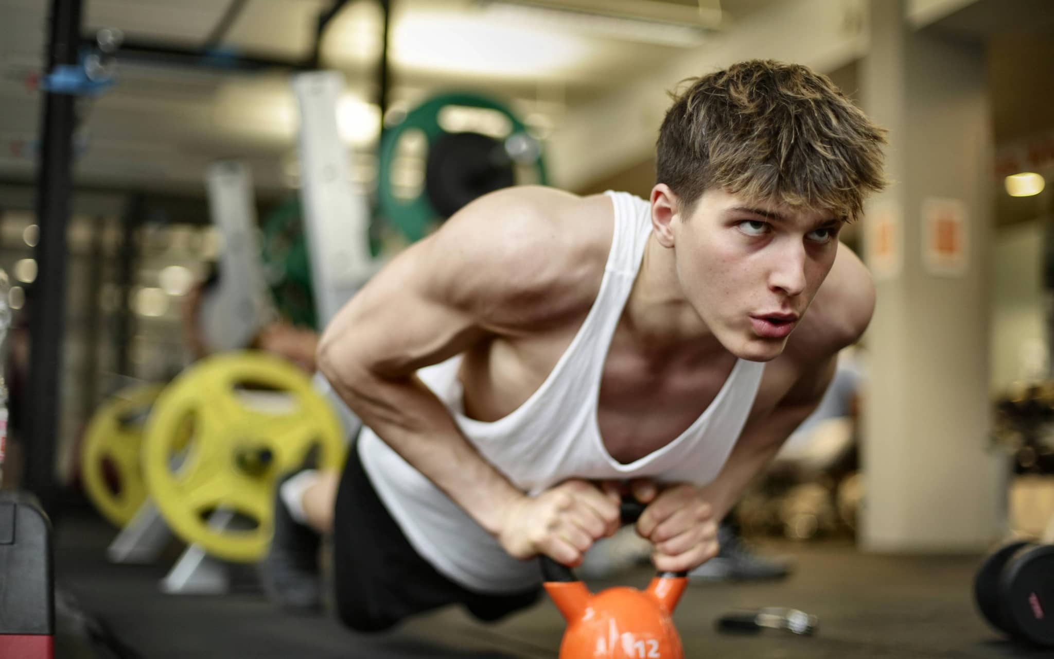 Penis-Unfälle: Junger Mann im Fitnessstudio beim Sport.