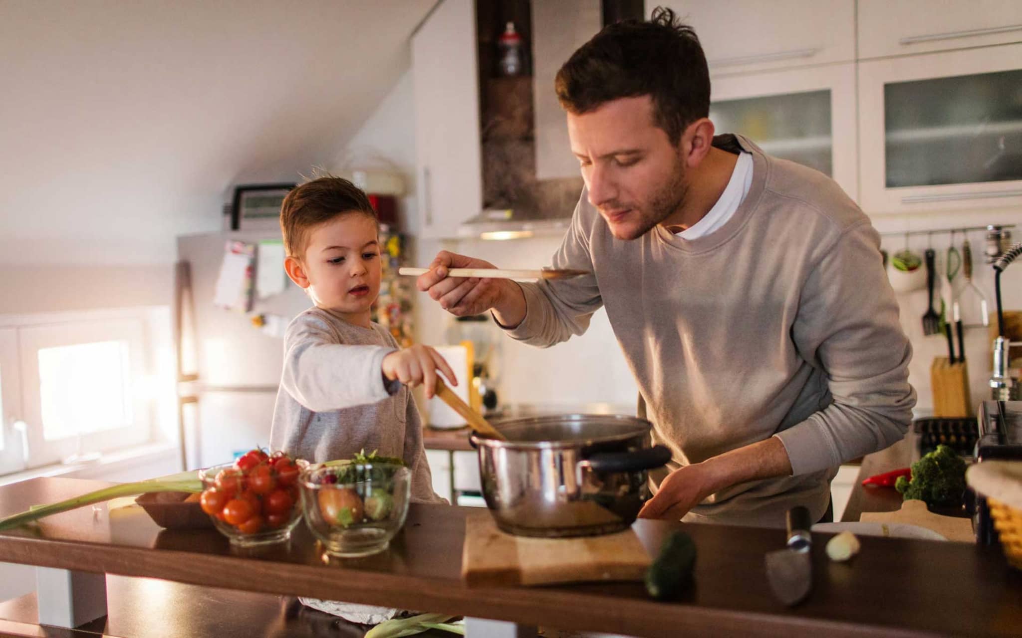 Symbolbild gesunde Suppen: Vater und Sohn kochen gemeinsam