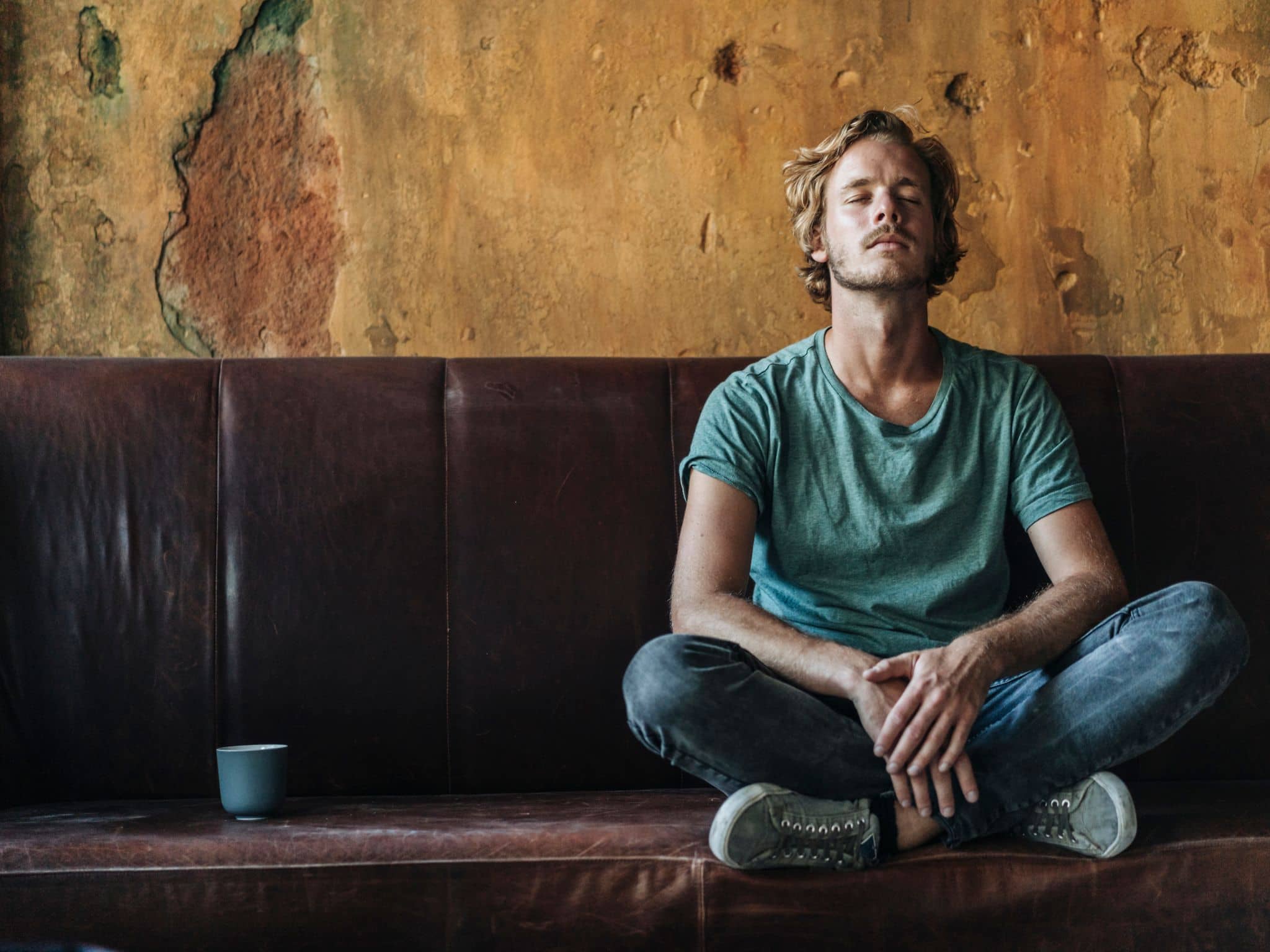 Bild: Mann sitzt mit geschlossenen Augen auf einer Couch.