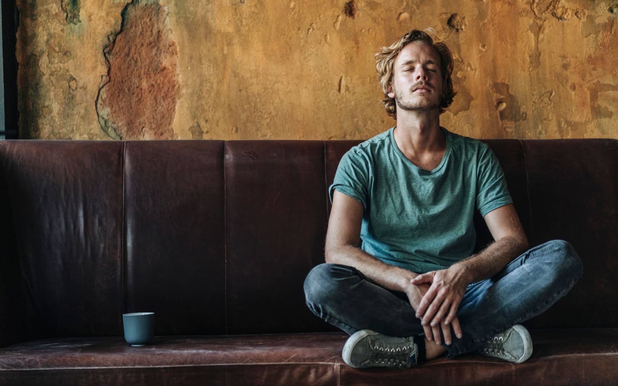 Bild: Mann sitzt mit geschlossenen Augen auf einer Couch.