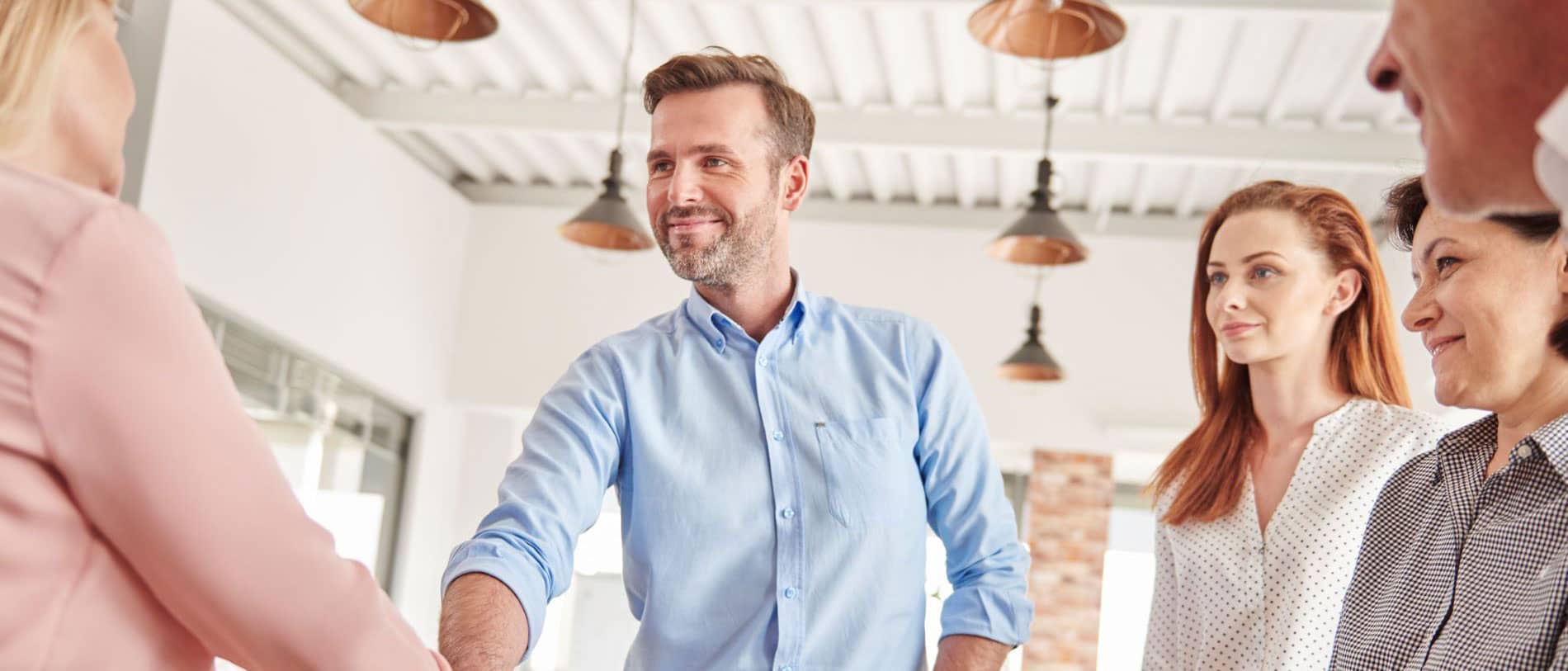 Bild: Team begrüßt eine neue Kollegin im Büro