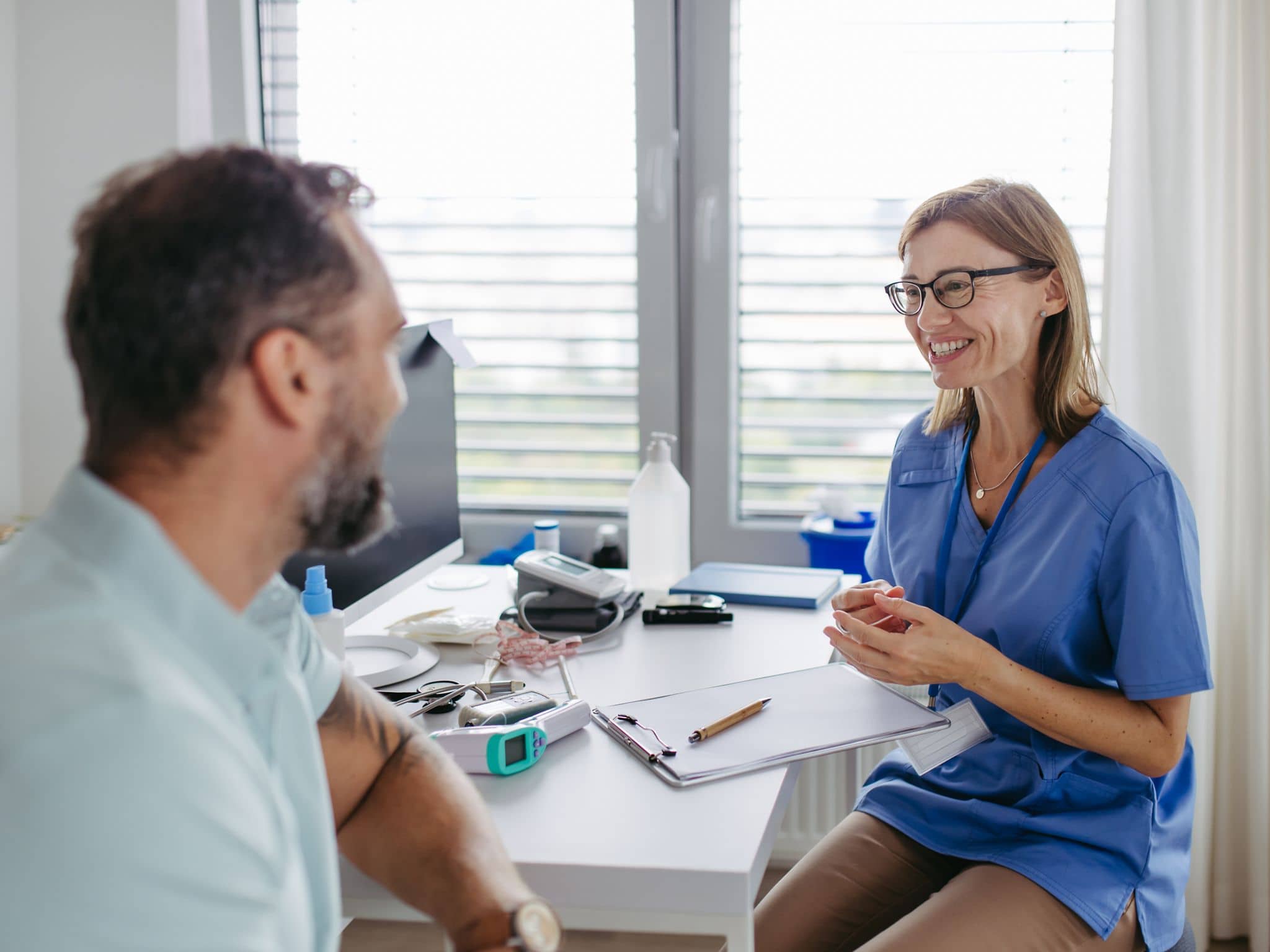 Slika: Pacijent i lekarka razgovaraju.
