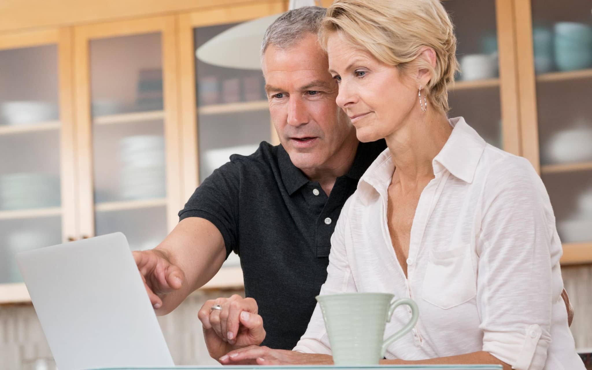Patientenverfügung: Älteres Paar schaut gemeinsam auf ein Notebook.