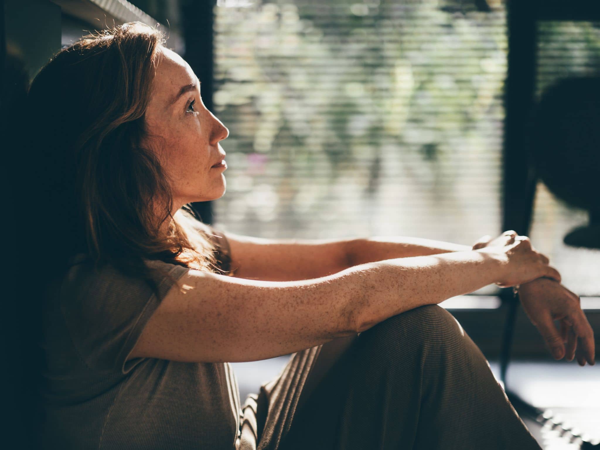Sexuelle Unlust in den Wechseljahren: Eine ältere Frau sitzt auf dem Fußboden und denkt nach