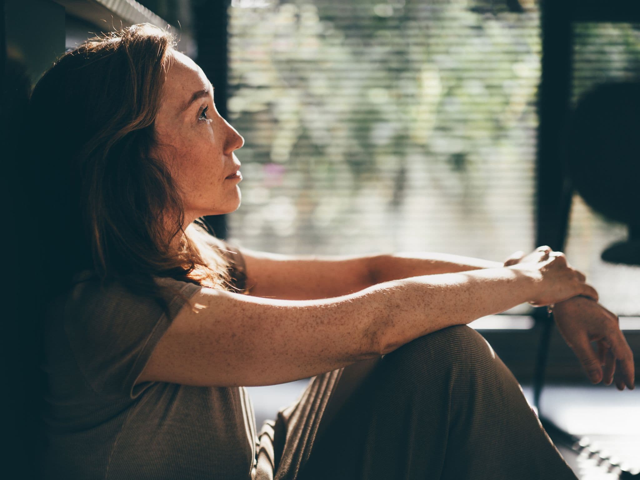 Sexuelle Unlust in den Wechseljahren: Eine ältere Frau sitzt auf dem Fußboden und denkt nach