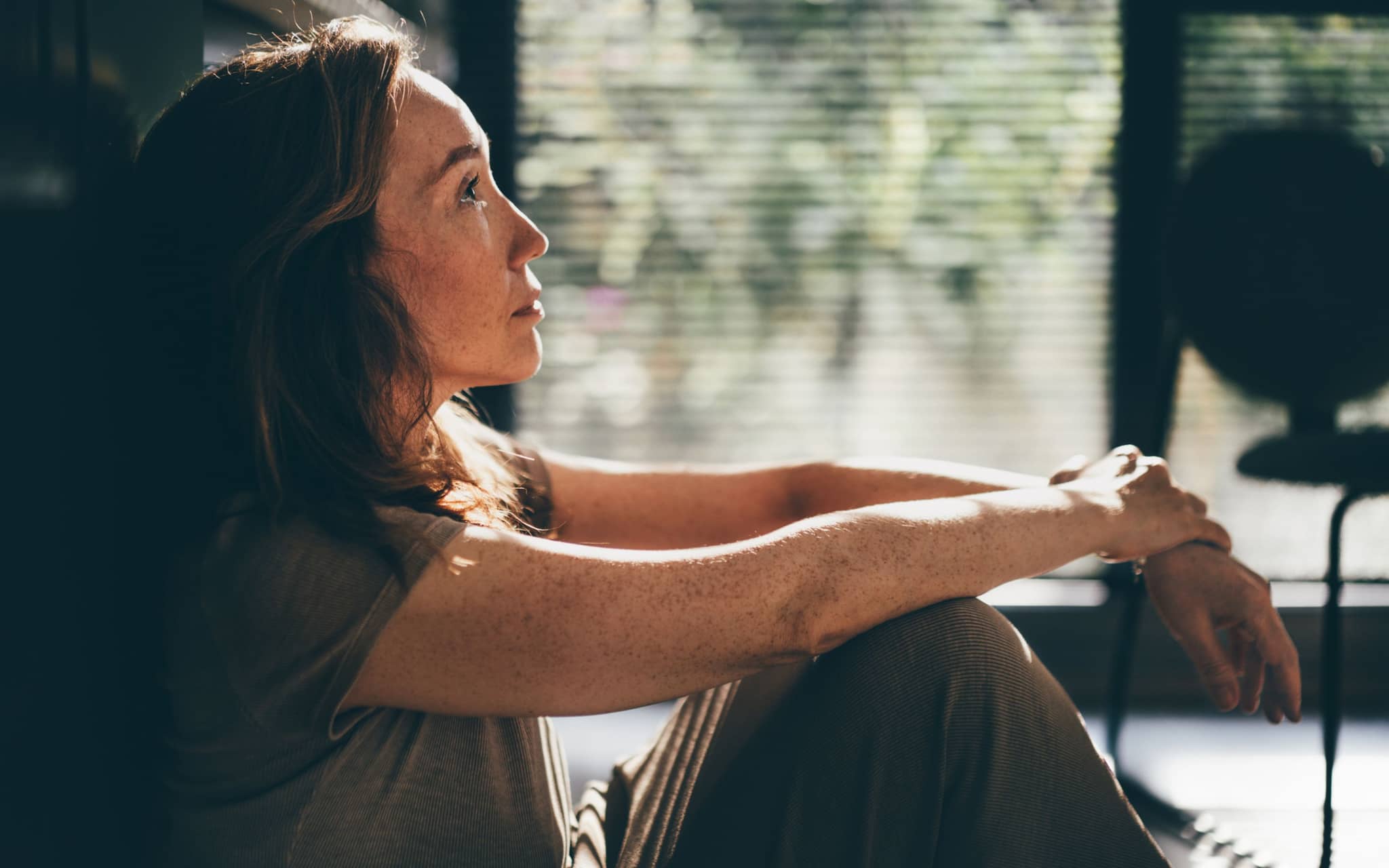 Sexuelle Unlust in den Wechseljahren: Eine ältere Frau sitzt auf dem Fußboden und denkt nach