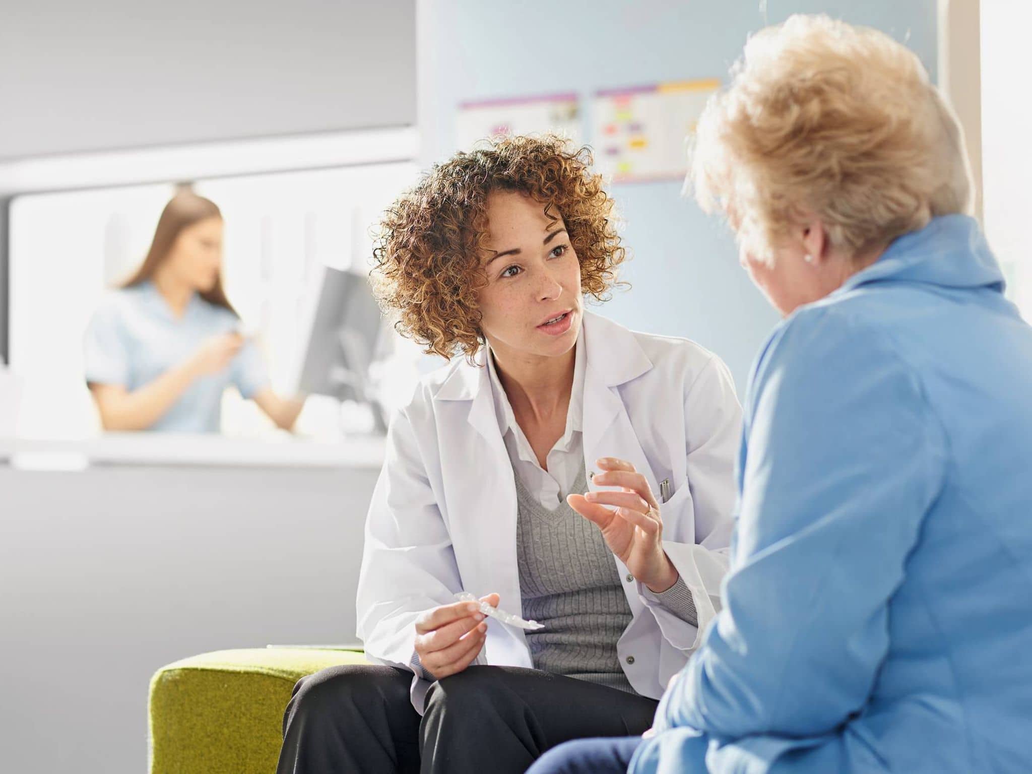 Bild: Ärztin hält Tablettenblister in der Hand und erklärt einer Patientin die Einnahme.