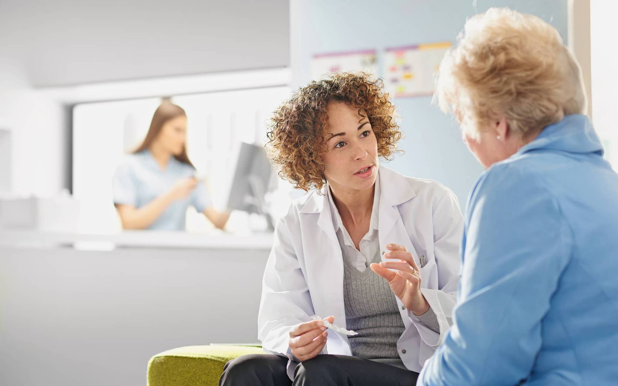 Bild: Ärztin hält Tablettenblister in der Hand und erklärt einer Patientin die Einnahme.