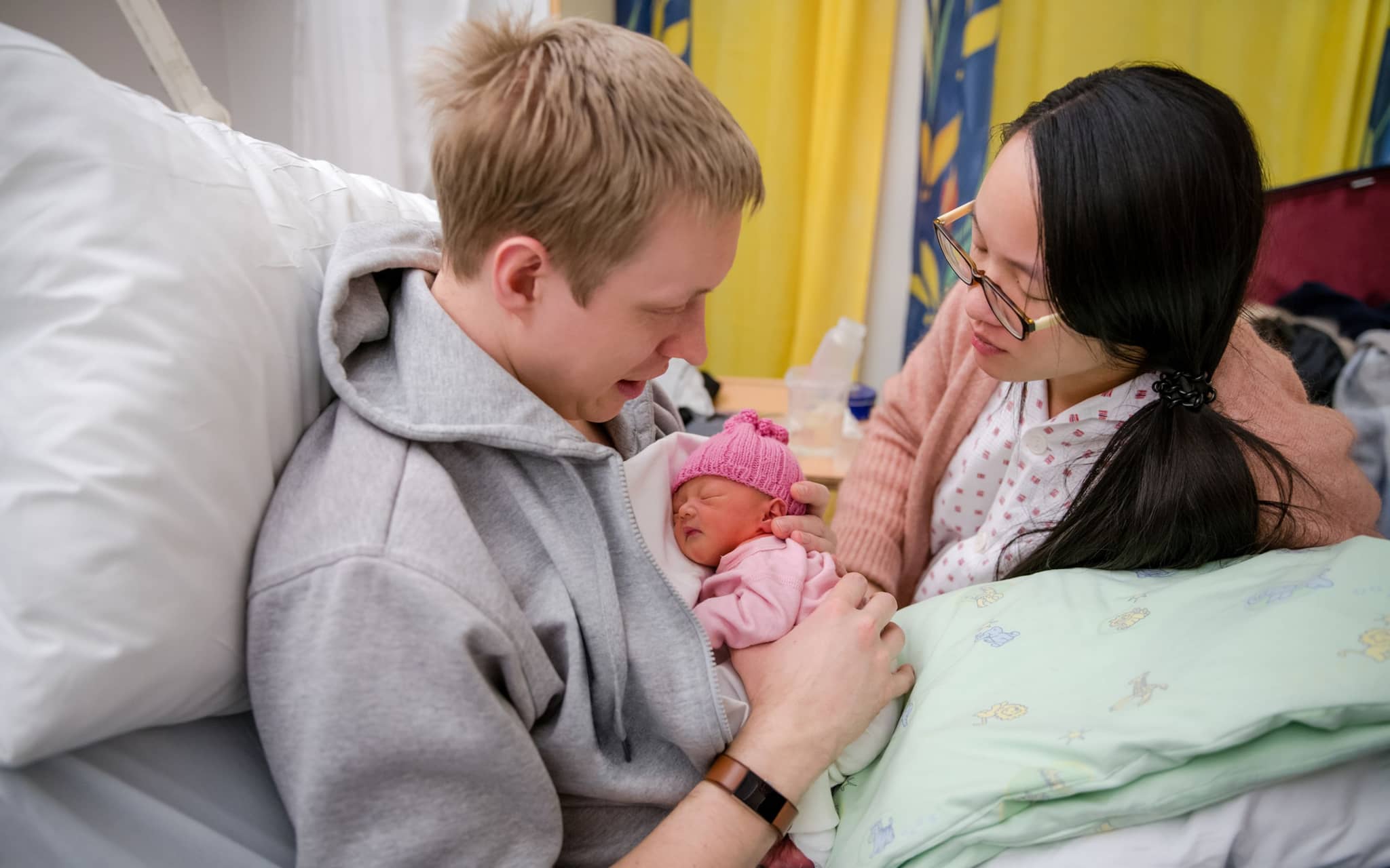 Frühchen: Ein junges Paar hält ihr kleines Neugeborenes im Arm