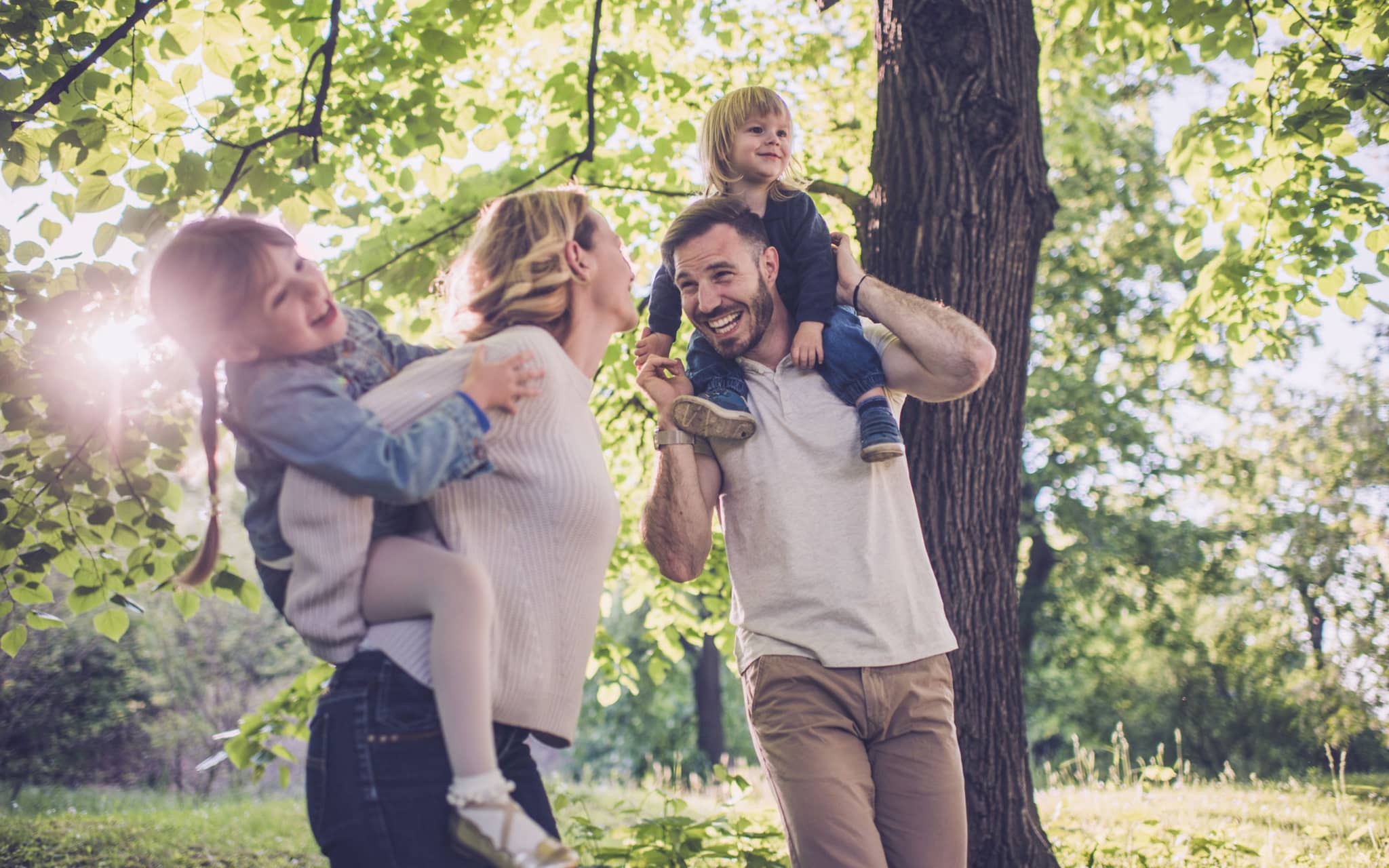 Klimaschutz und Nachhaltigkeit: Lachendes Paar mit zwei kleinen Kindern in der Natur.