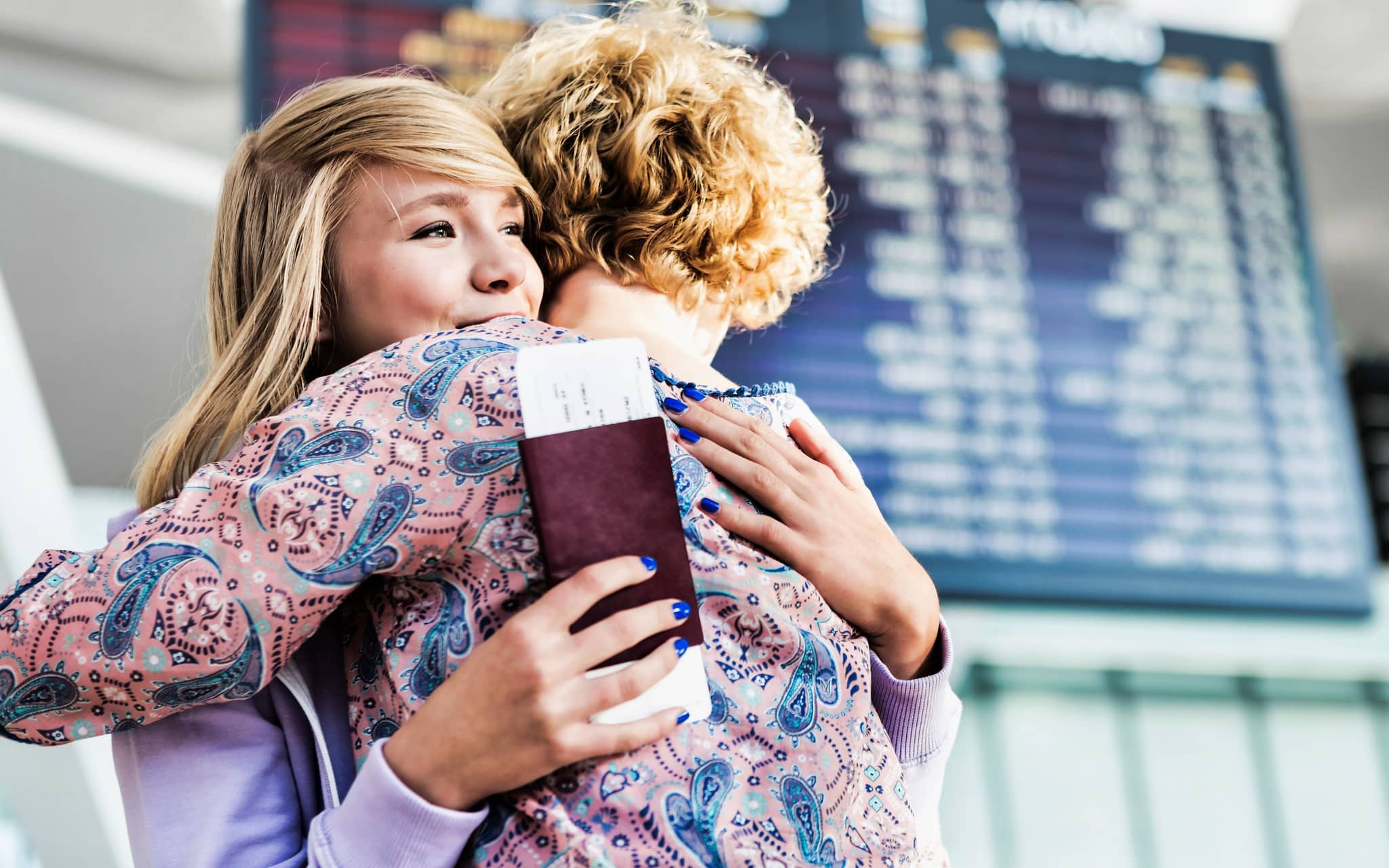 Eine Mutter verabschiedet ihre Tochter am Flughafen. Die Familienversicherung gilt oftmals auch im Ausland.