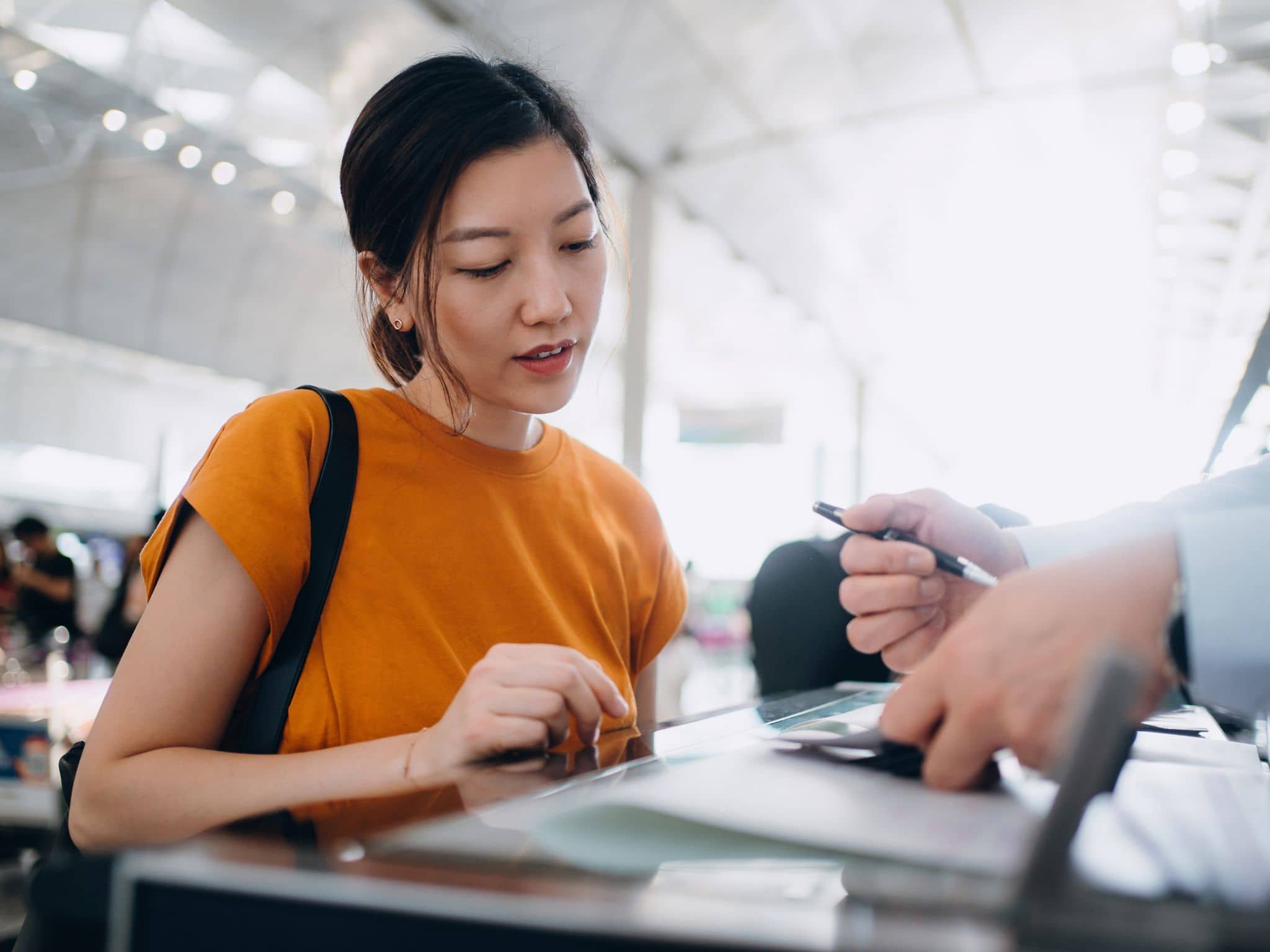 Young Asian woman at the airport getting her visa checked.