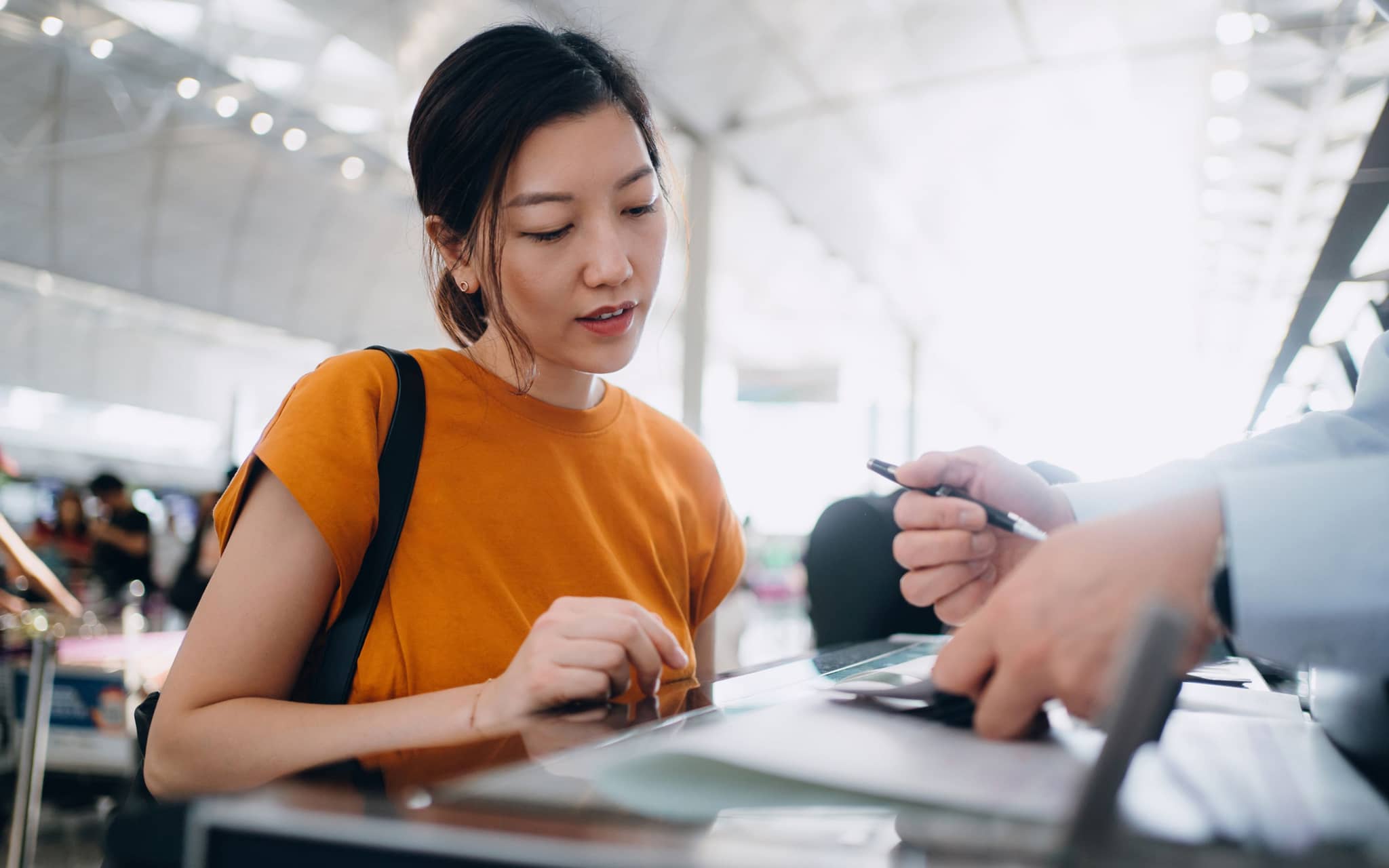Young Asian woman at the airport getting her visa checked.