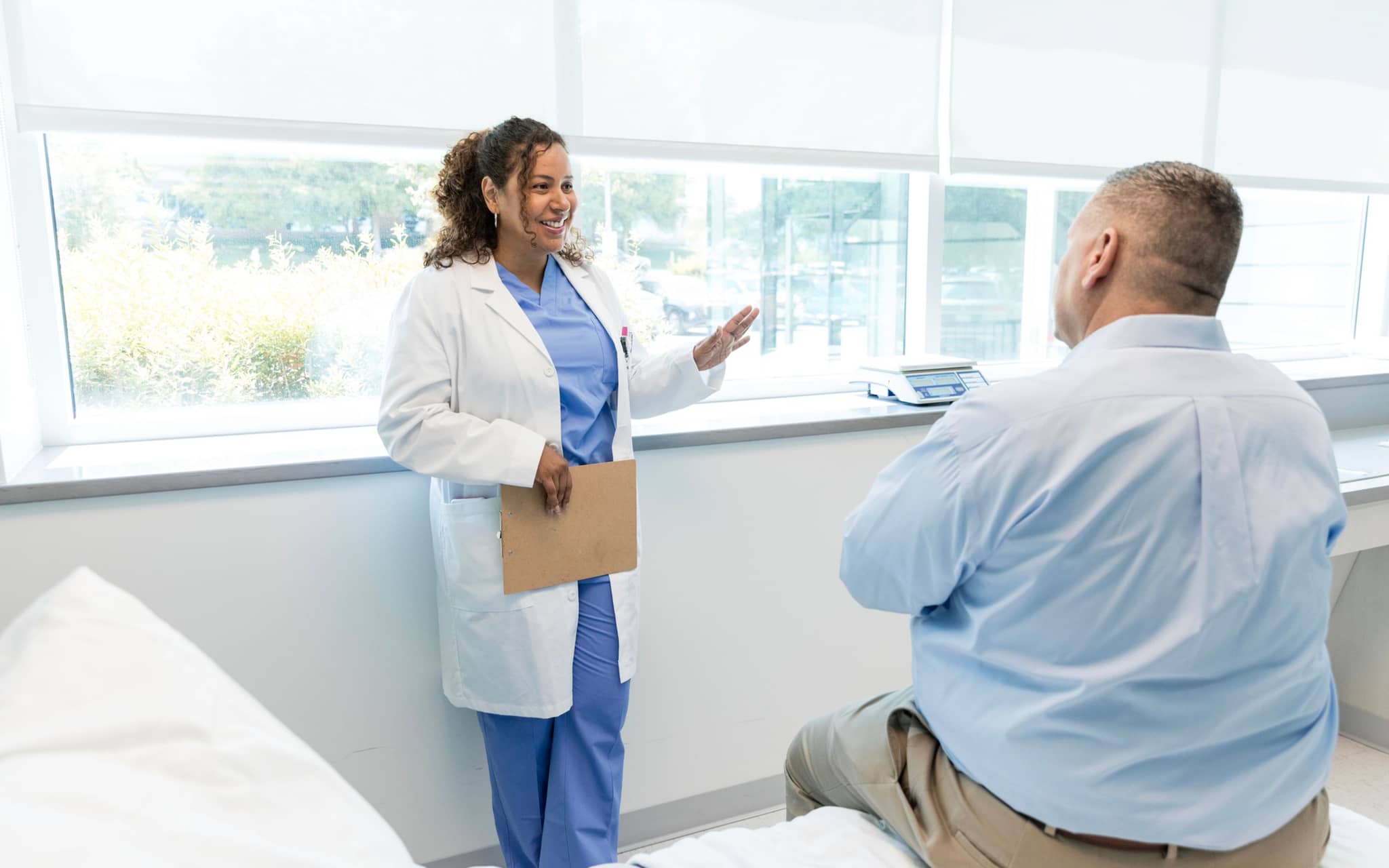 Bild: Ärztin spricht mit einem Patienten mit Adipositas.