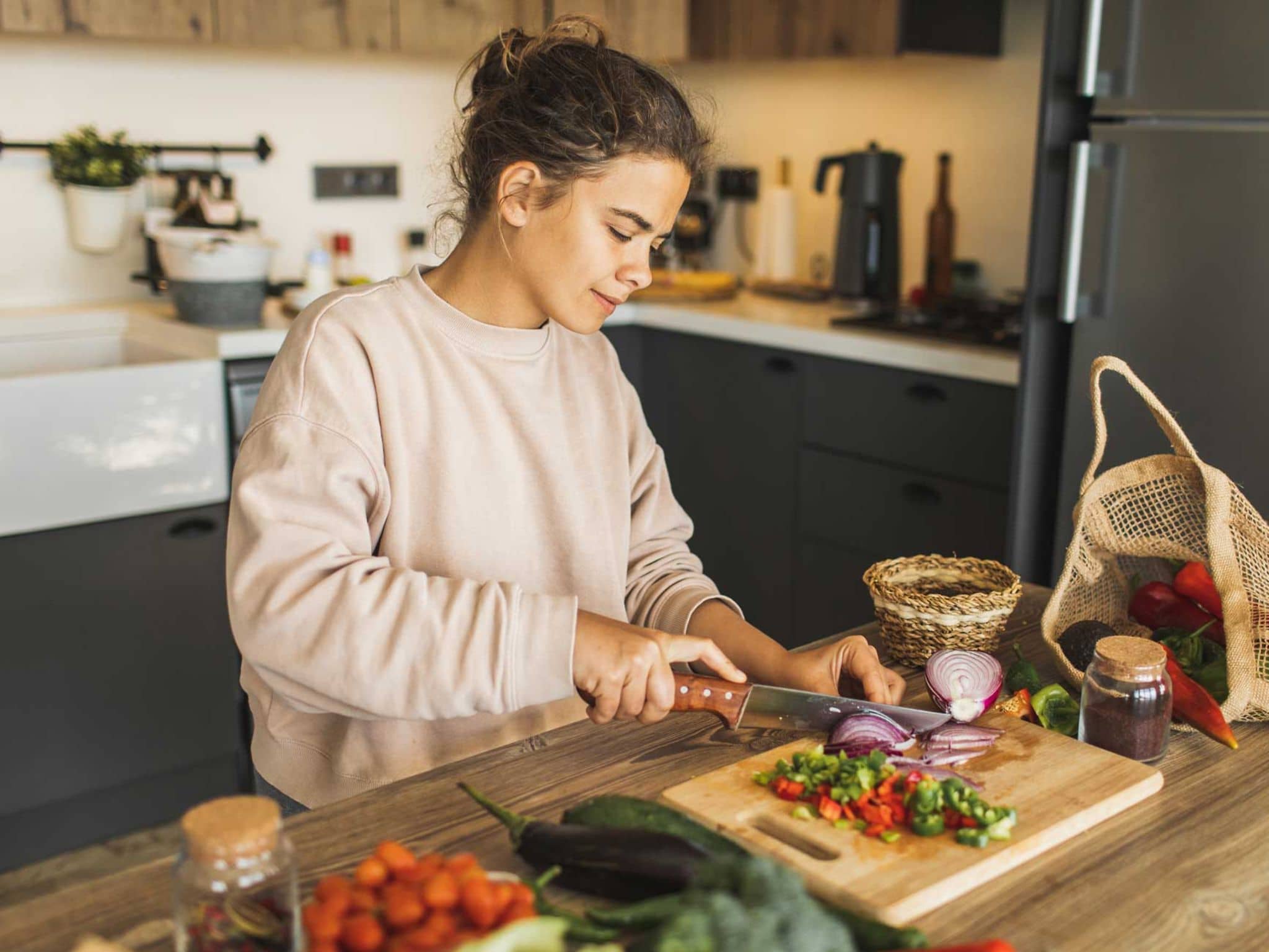 Vegetarische Ernährung: Frau schneidet Gemüse in Küche