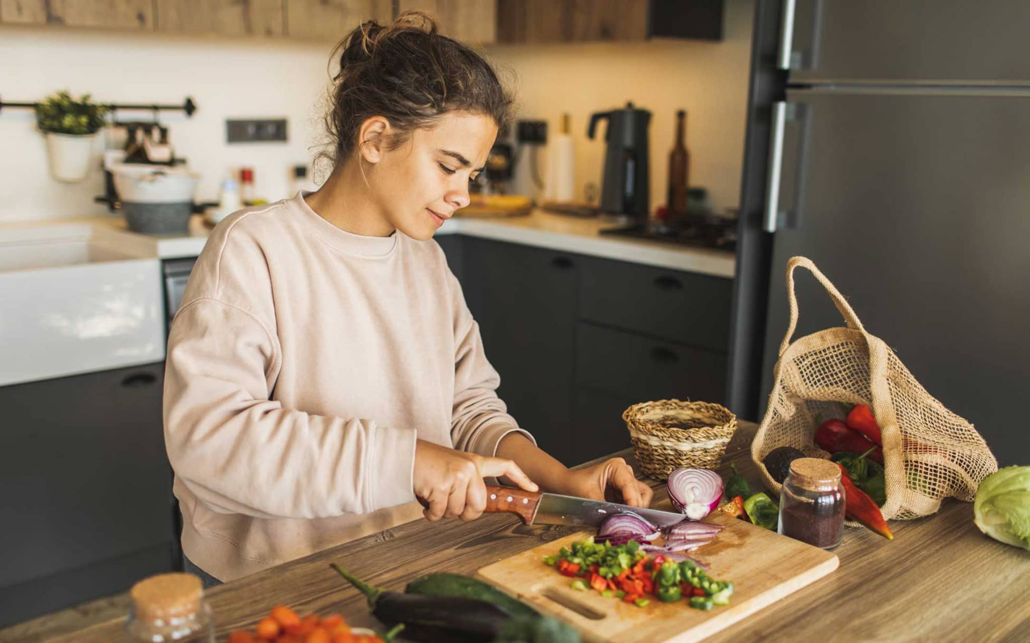 Vegetarische Ernährung: Frau schneidet Gemüse in Küche