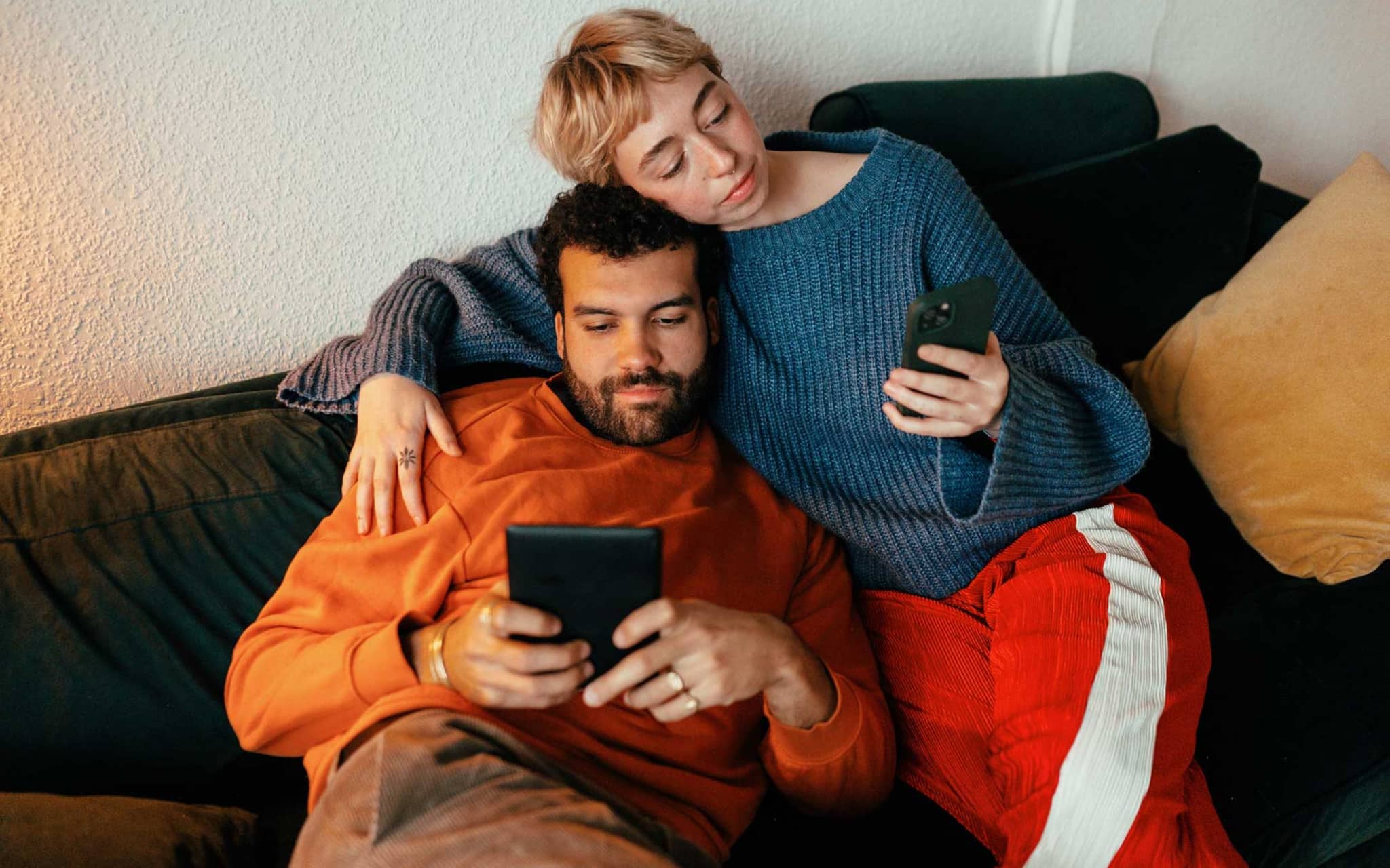 Auswirkungen von Social Media: Paar mit Handy auf der Couch