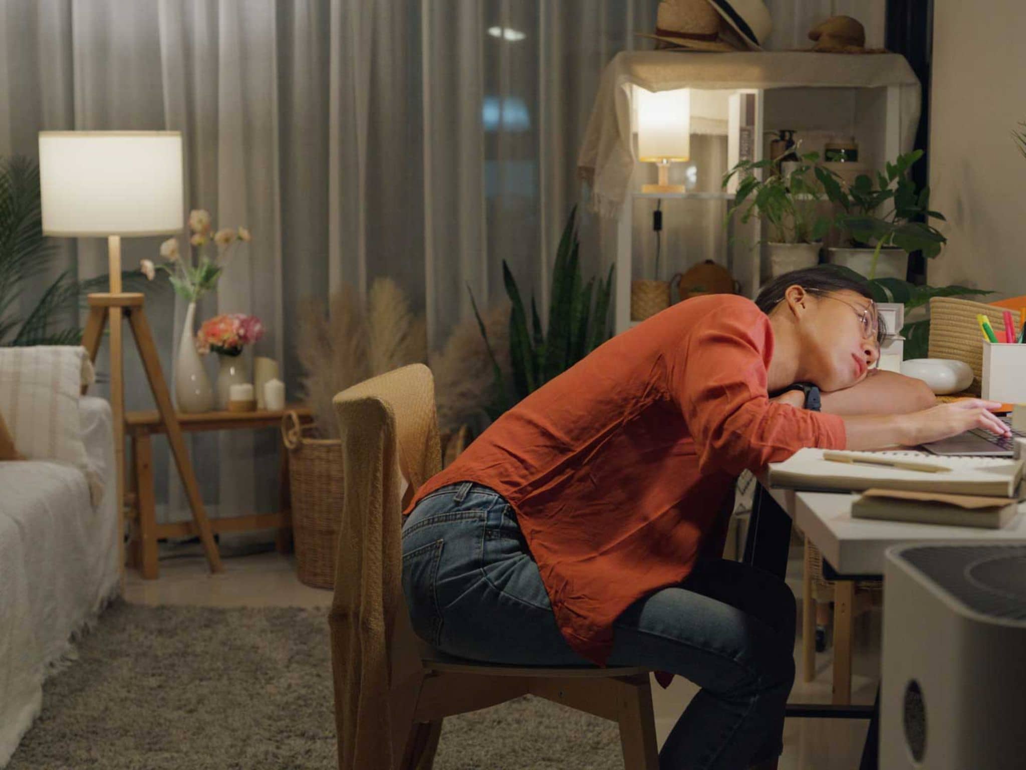 Prokrastination: Junge Frau sitzt lustlos vor dem Laptop