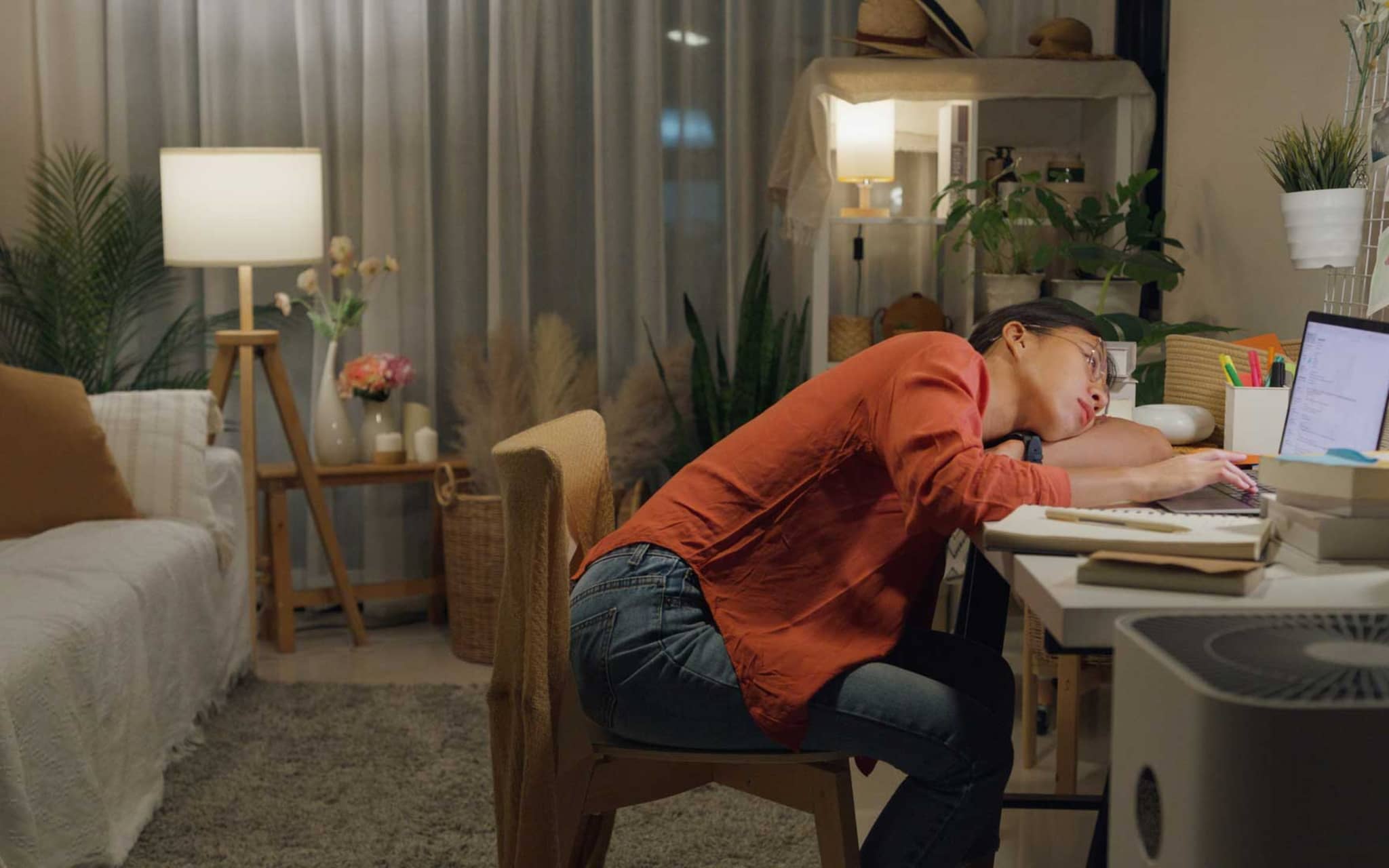 Prokrastination: Junge Frau sitzt lustlos vor dem Laptop