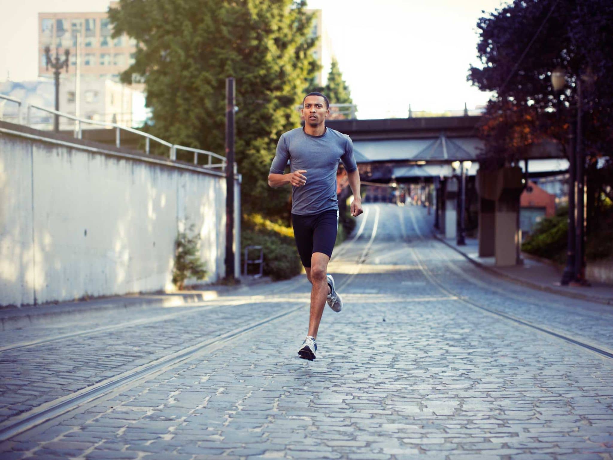 Übertraining: Junger sportlicher Mann läuft durch Stadt