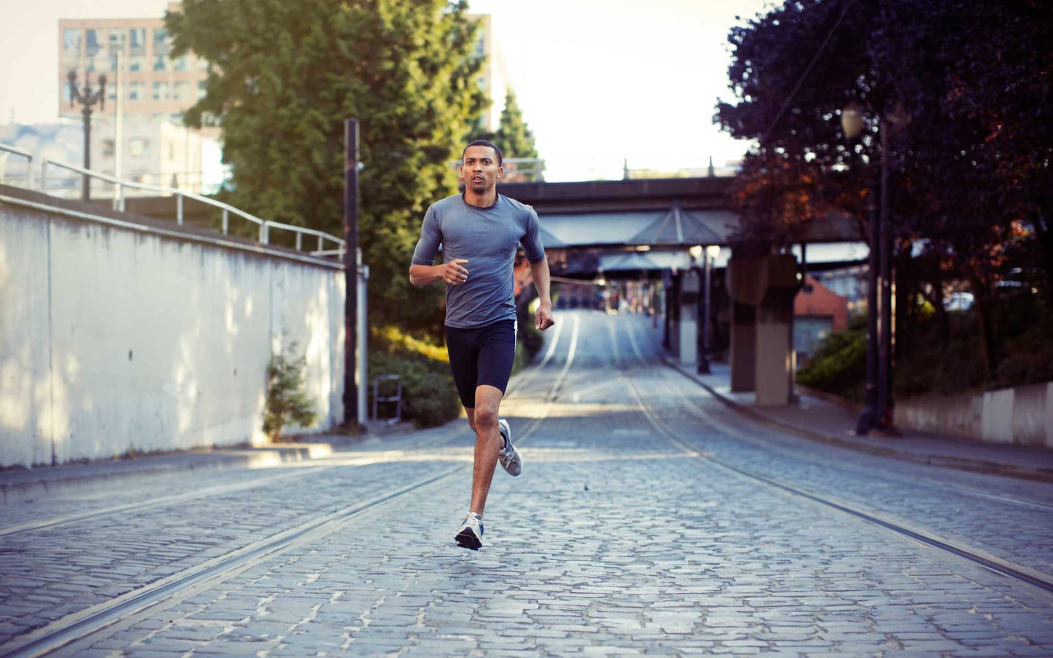 Übertraining: Junger sportlicher Mann läuft durch Stadt