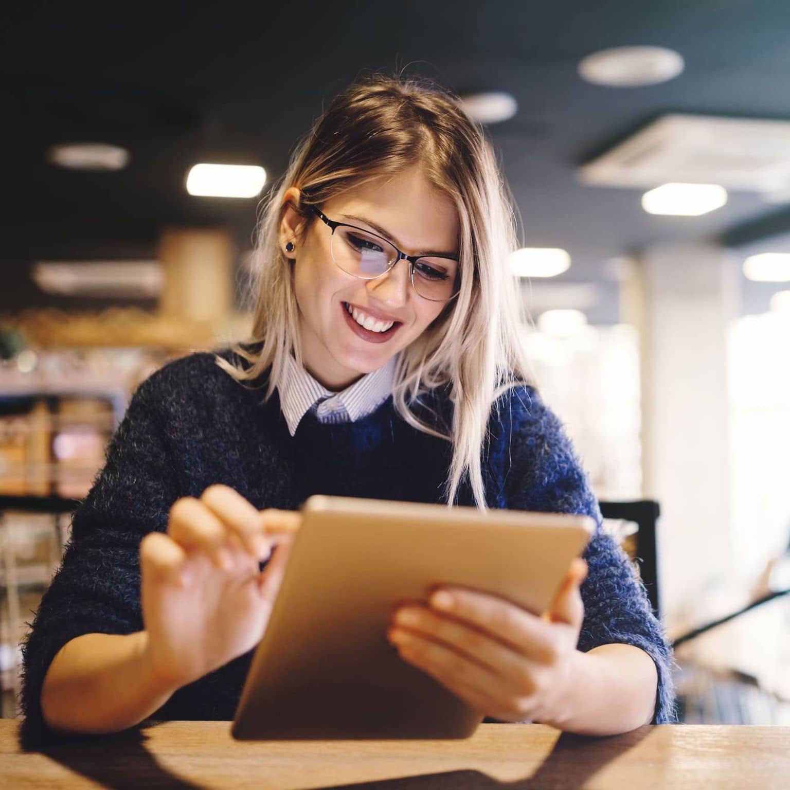 Image: Smiling woman checking the DAK website on a tablet.