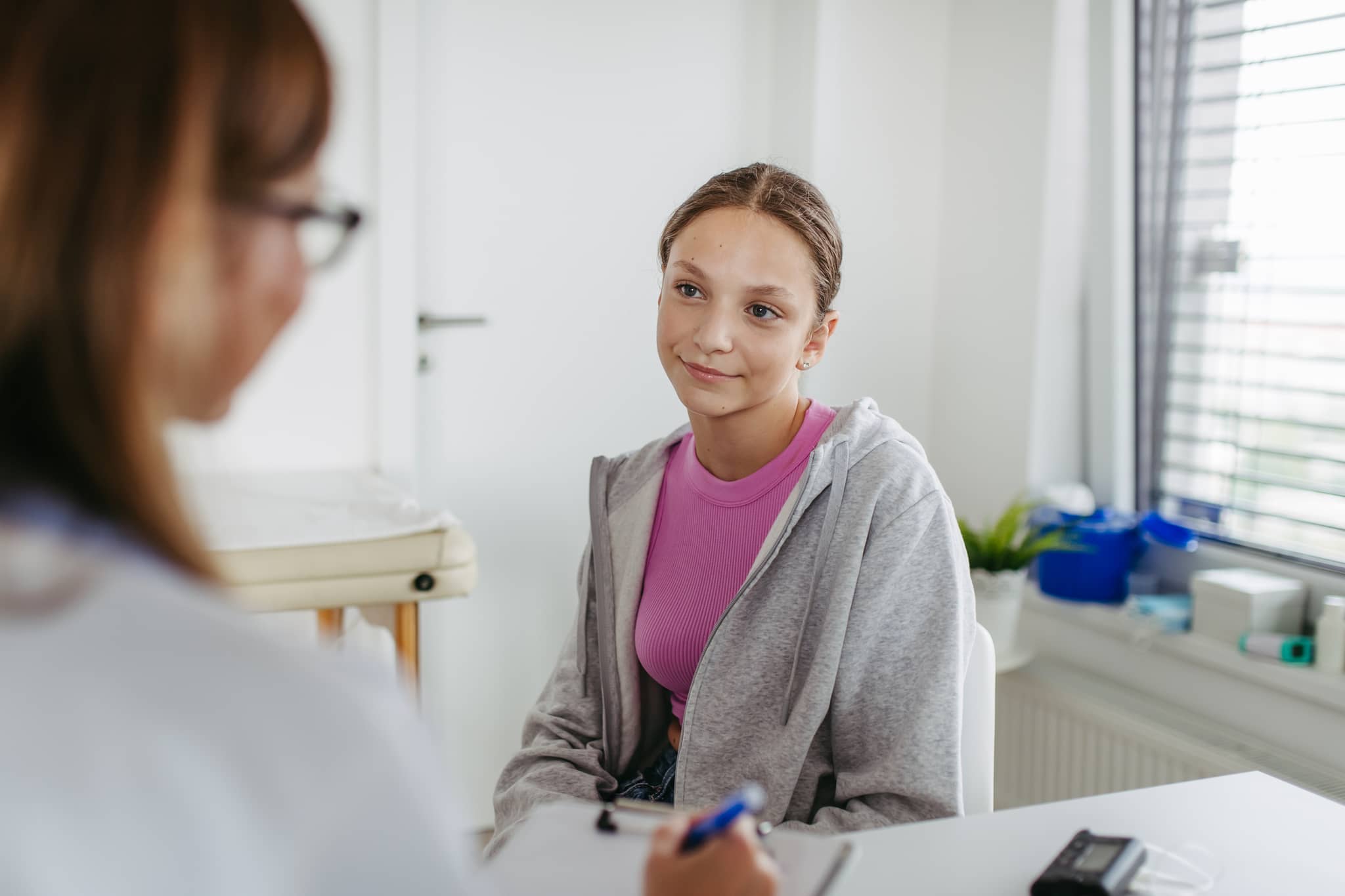 HPV-Impfung: Mädchen unterhält sich mit Ärztin über eine HPV-Impfung