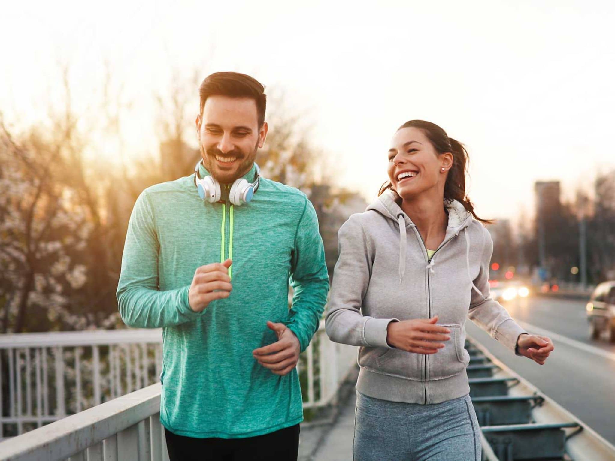 Läuferknie: Zwei Freunde joggen eine Straße entlang