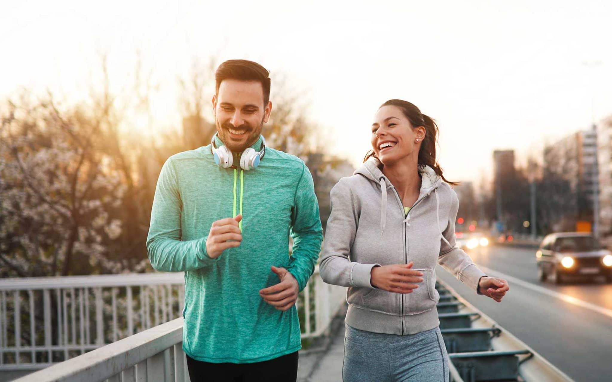 Läuferknie: Zwei Freunde joggen eine Straße entlang