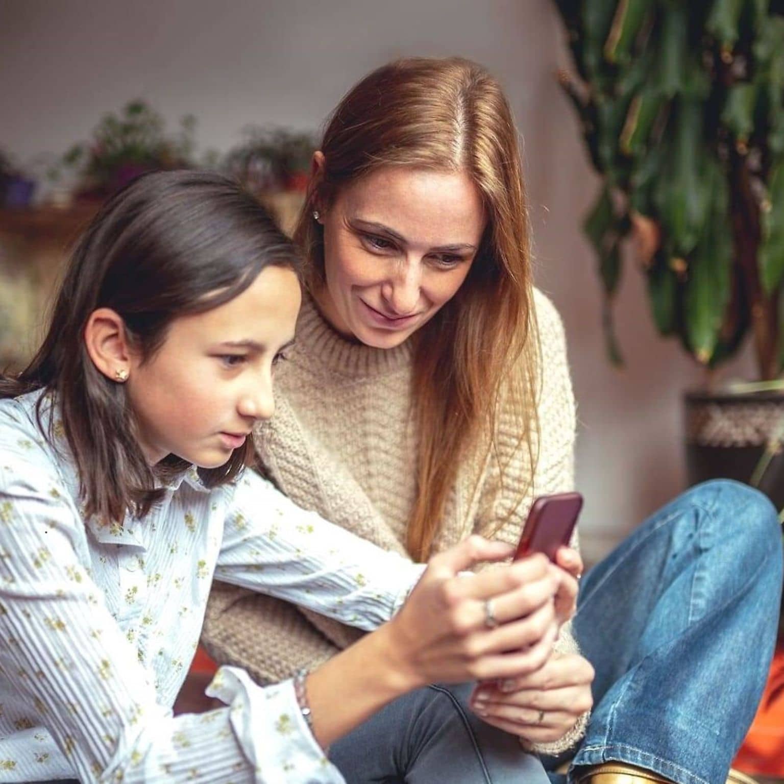 Bild: Tochter zeigt ihrer Mutter etwas auf dem Handy.